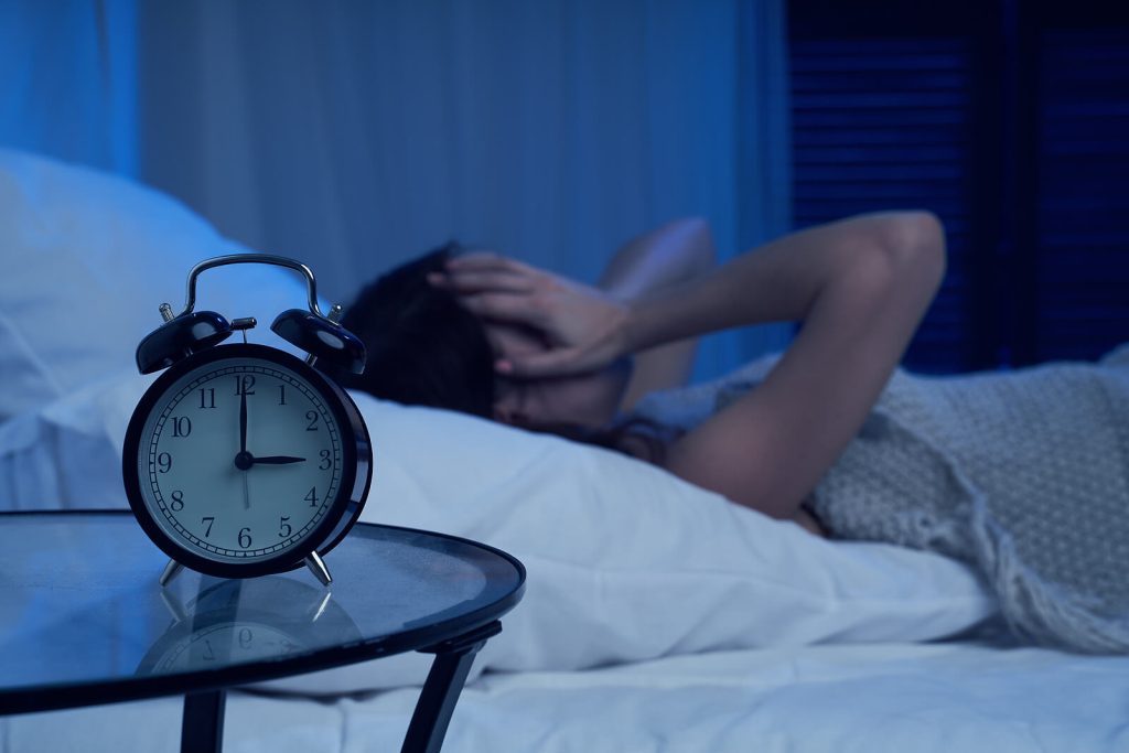 Woman lying in bed struggling to sleep. If insomnia is keeping you up at night and you feel its impacting your daily life, insomnia treatment in Arizona can help you restore you sleep pattern.