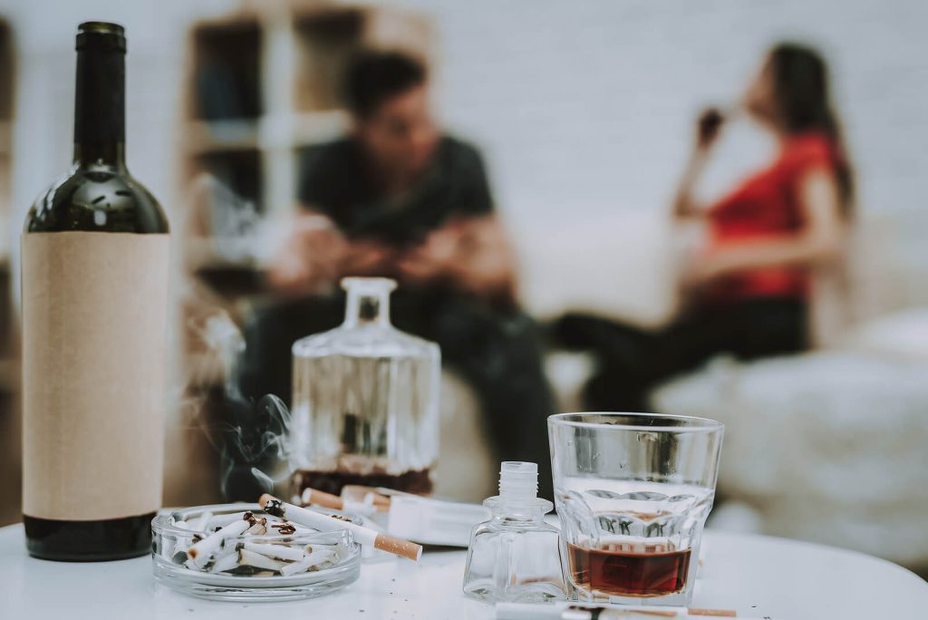 Image of alcohol in a decanter with people in the background represennting the struggle with alcohol abuse. If alcohol use has become needed to function, our outpatient substance abuse treatment in Arizona is here to help end your dependence on substances. Learn more here.